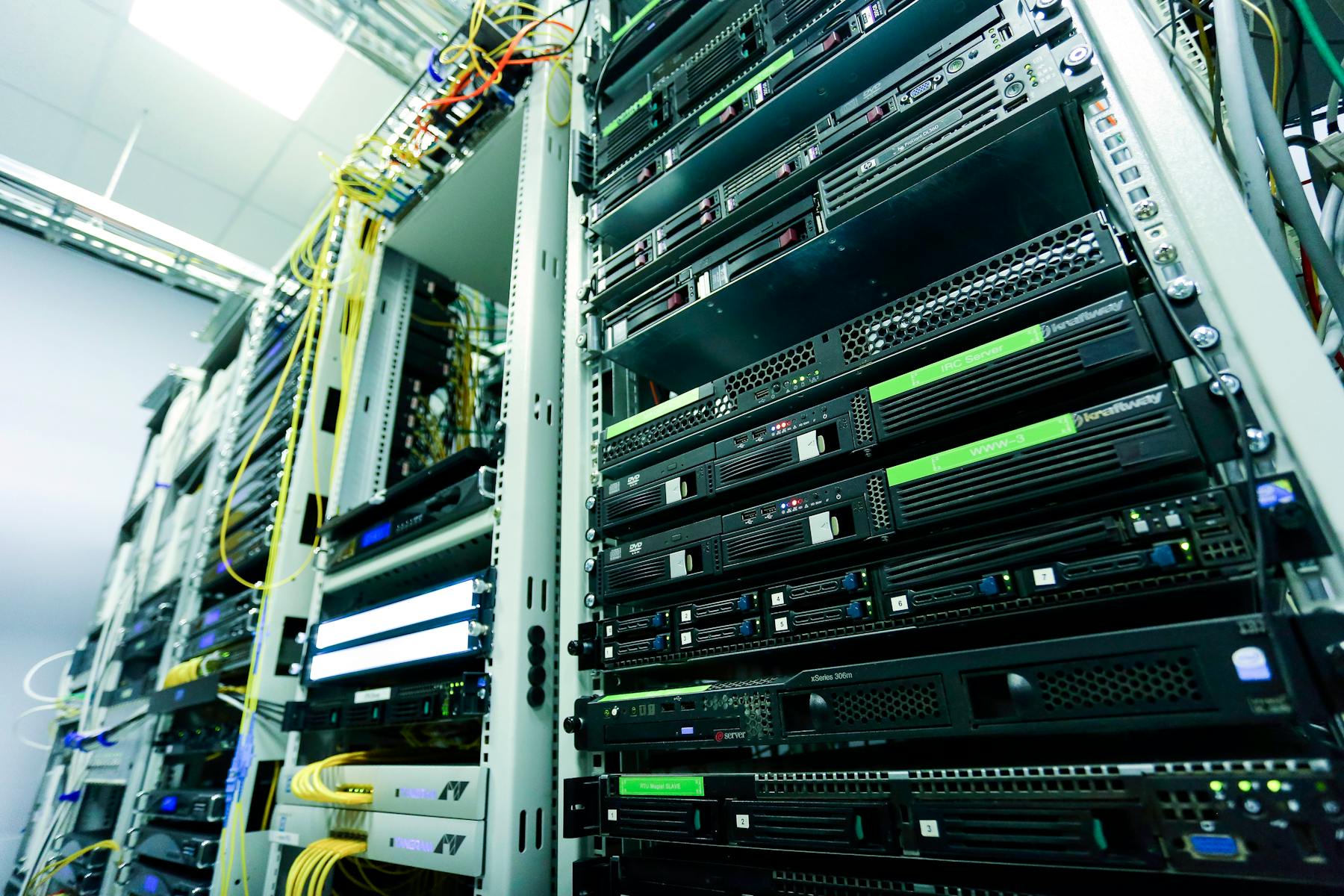 Stacked network servers inside an enclosure with yellow patch cables